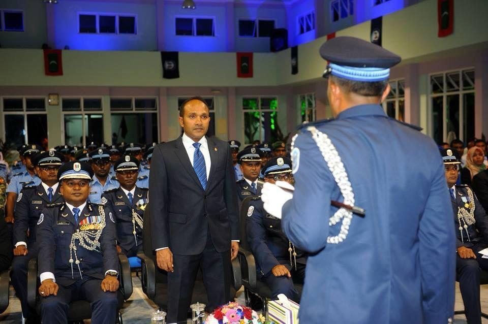 Dr Jameel standing before seated ranks of officers in dress uniform as one officer salutes him.