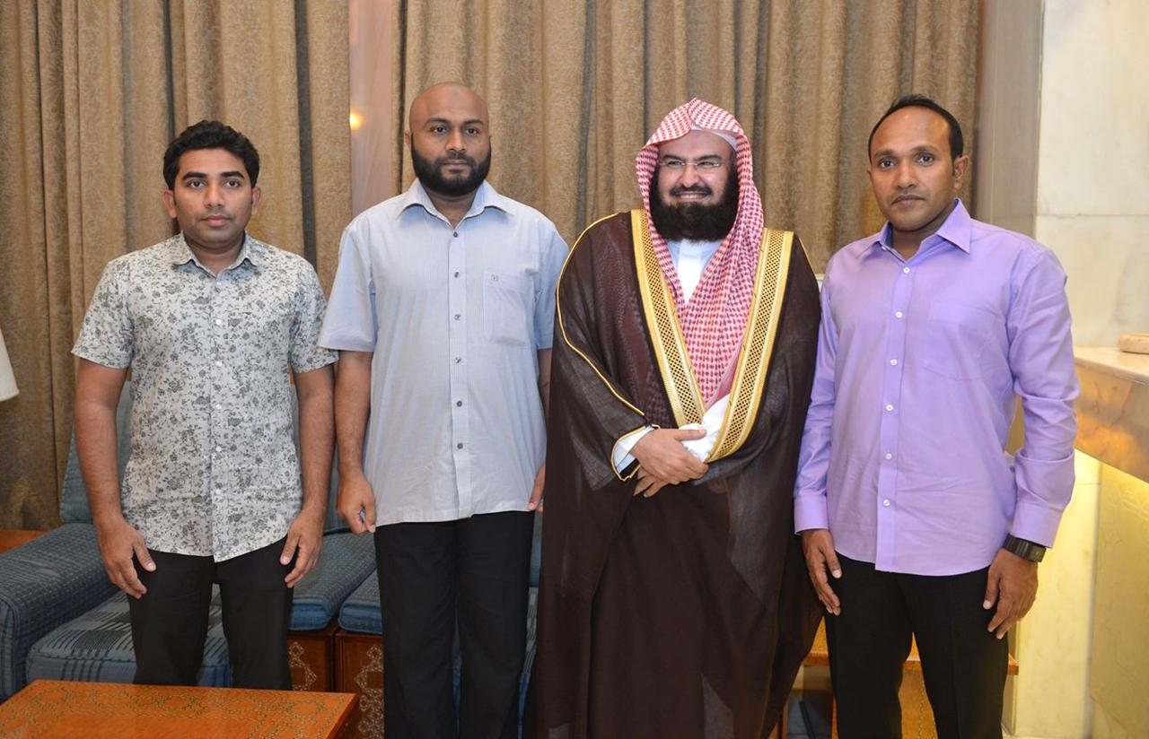 A group photograph of Dr Jameel and three others with a visiting scholar in a reception room.